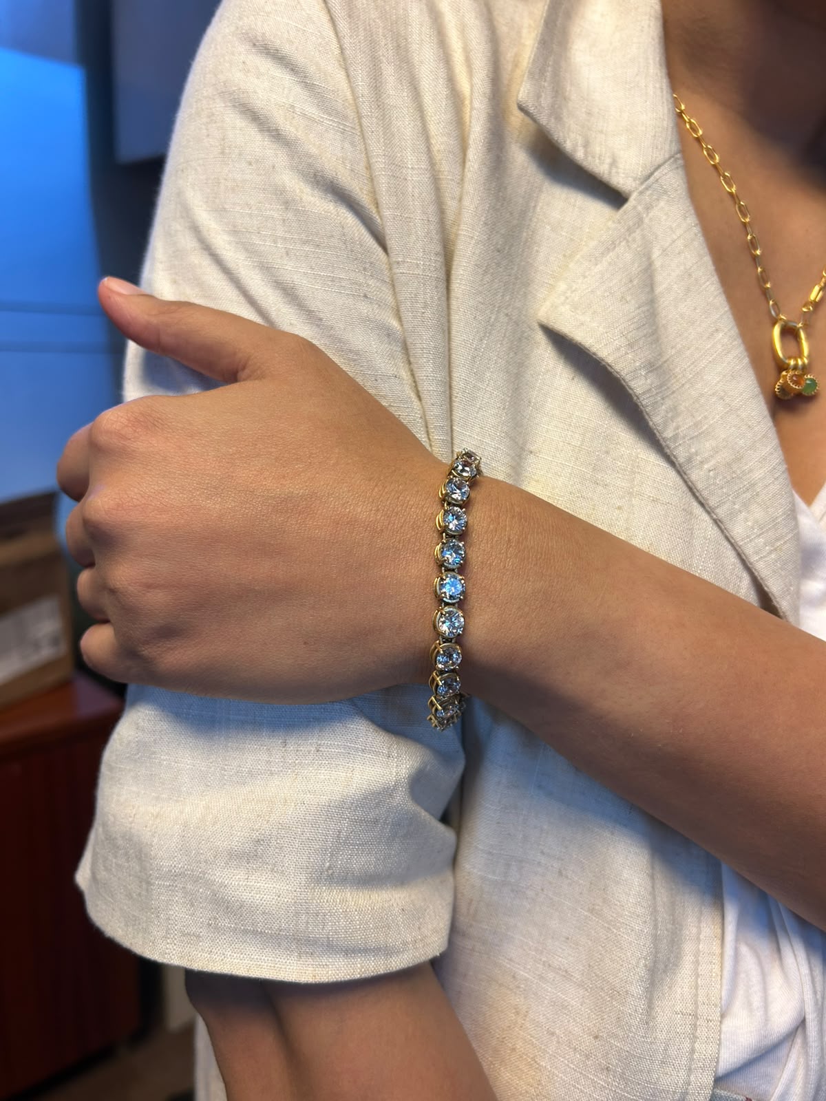 Vintage Solitaire antique gold crystal tennis bracelet worn on wrist, styled with gold chain necklace
